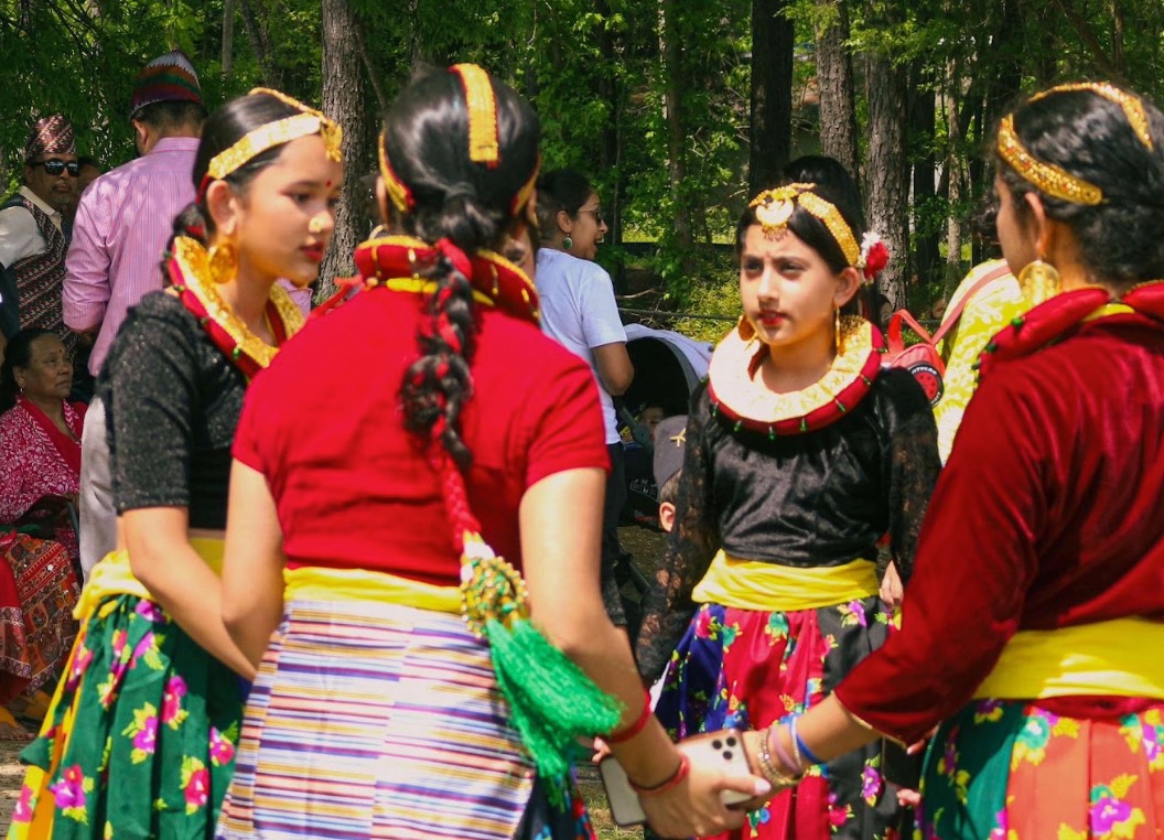 Girls in traditional Nepali dress holding hands in a circle dance
