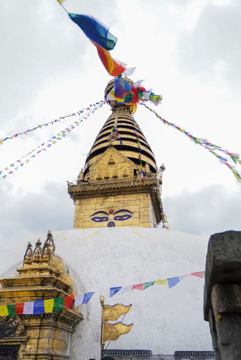 Prayer flags streaming from the golden spire of Swayambhunath stupa in Kathmandu